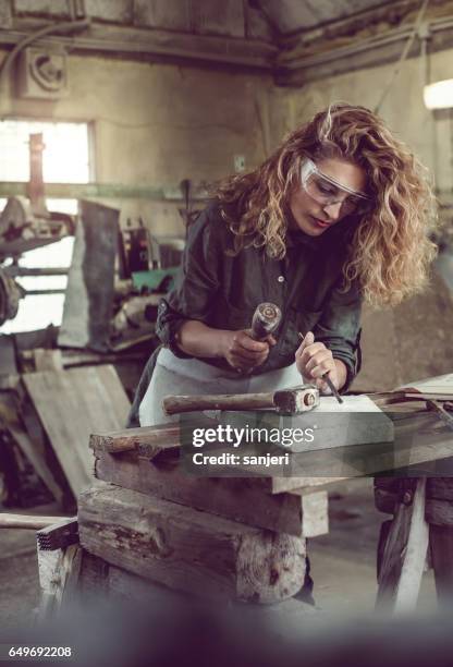 female stonecutter carving the stone - sculptor stock pictures, royalty-free photos & images