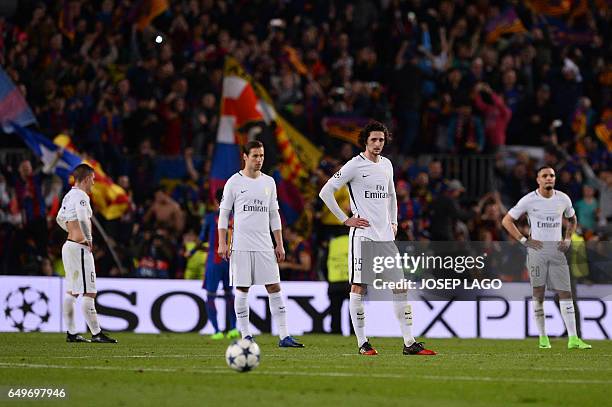 Paris Saint-Germain's midfielder Adrien Rabiot and teammates stand on the pitch after Barcelona's midfielder Sergi Roberto scored his team's victory...