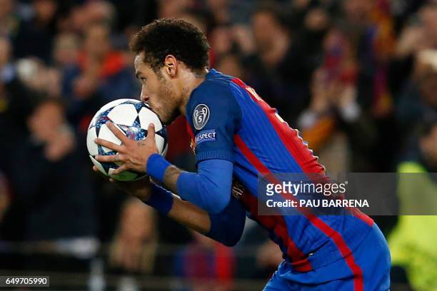 Barcelona's Brazilian forward Neymar kisses the ball as he celebrates after scoring during the UEFA Champions League round of 16 second leg football...