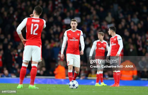 Aaron Ramsey of Arsenal stands dejected with his team mates during the UEFA Champions League Round of 16 second leg match between Arsenal FC and FC...