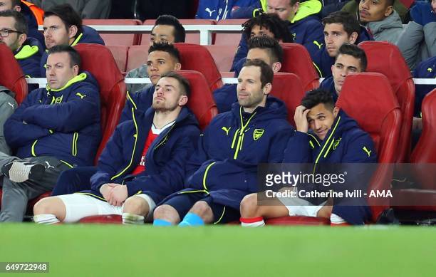 Aaron Ramsey, Petr Cech and Alexis Sanchez of Arsenal watch from the bench during the UEFA Champions League Round of 16 second leg match between...