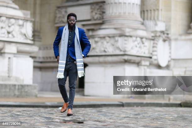 Sidya Sarr wears a Zara gray scarf, a BGarbo blue jacket, a shirt, Asos gray denim pants, and Finsbury brown leather shoes, outside the Elie Saab...