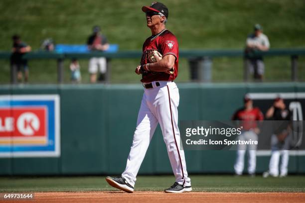 Arizona Diamondbacks first base coach Dave McKay watches warm up before the spring training baseball game between the Oakland Athletics and the...