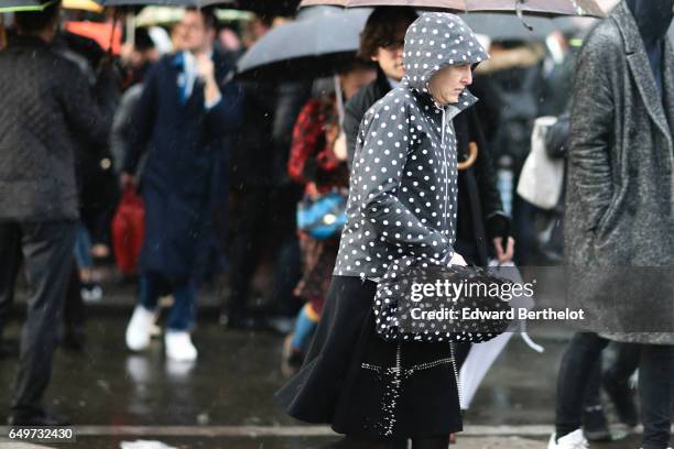 Guest wears a black coat with white dots, outside the Comme des Garcons show, during Paris Fashion Week Womenswear Fall/Winter 2017/2018, on March 4,...