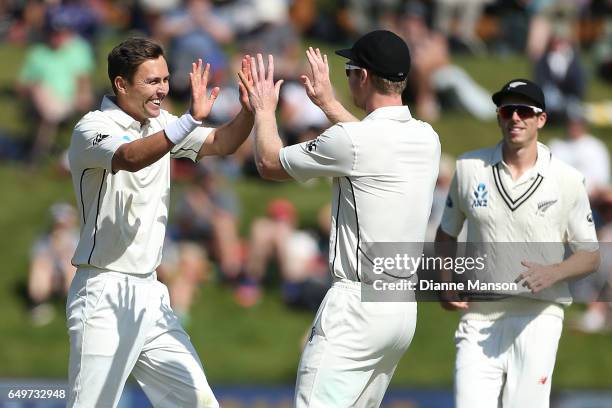 Trent Boult and Jimmy Neesham of New Zealand celebrate the dismissal of Temba Bavuma during day two of the First Test match between New Zealand and...