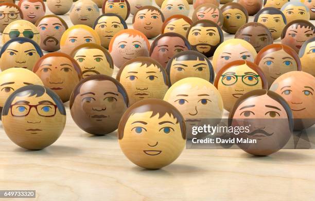 wooden balls with multi-ethnic faces on them. (low angle view) - multiculturalism faces stock pictures, royalty-free photos & images