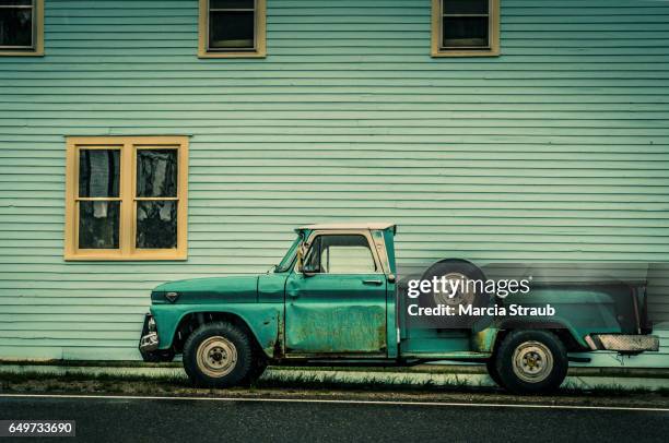 old green truck against green building - old truck fotografías e imágenes de stock