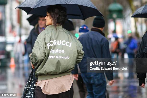 Guest wears a green bomber jacket, outside the Comme des Garcons show, during Paris Fashion Week Womenswear Fall/Winter 2017/2018, on March 4, 2017...