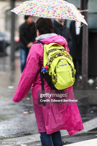 Guest wears a Jansport yellow backpack, and a multicolor umbrella, outside the Comme des Garcons show, during Paris Fashion Week Womenswear...