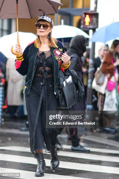 Guest wears a checked beret hat, a flower print jacket, a mesh top, cropped jeans, and black boots, outside the Comme des Garcons show, during Paris...