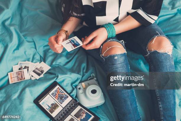 girl enjoying photos from the vacation - album stock pictures, royalty-free photos & images