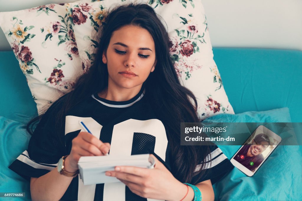 Woman making notes in bed