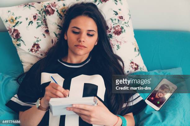 woman making notes in bed - love letter stock pictures, royalty-free photos & images
