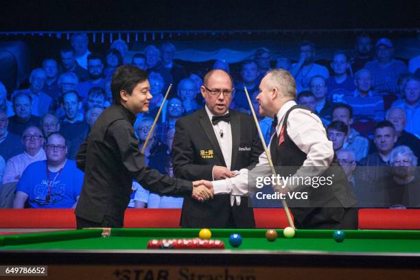 Ding Junhui of China shakes hands with John Higgins of Scotland during the first round match on day three of 2017 Ladbrokes Players Championship at...