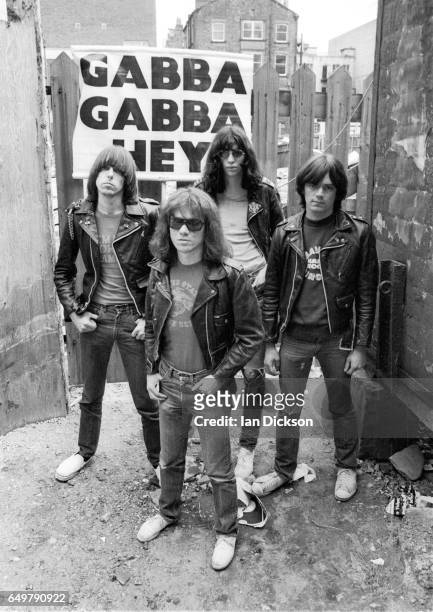 The Ramones pose for a group portrait with their 'Gabba Gabba Hey' placard near Eric's club, Liverpool, 19th May 1977. Left to right: Johnny Ramone,...