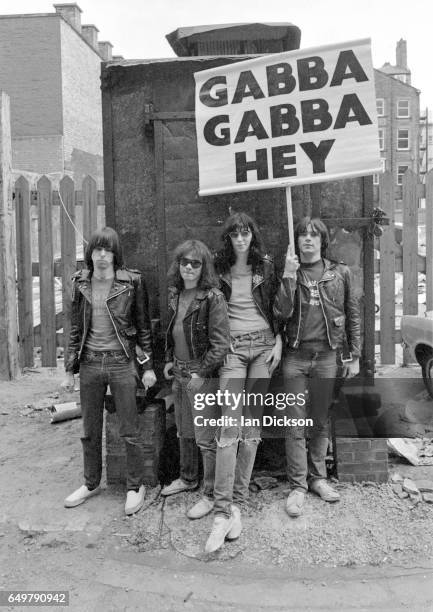 The Ramones pose for a group portrait with their 'Gabba Gabba Hey' placard near Eric's club, Liverpool, 19 May 1977. L-R Johnny Ramone, Tommy Ramone,...