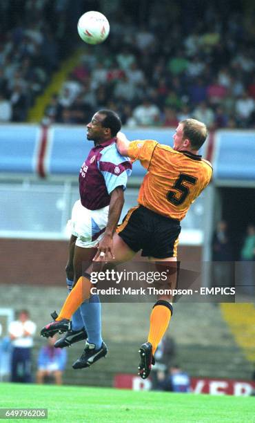 Cyrille Regis, Aston Villa, beats Nick Clarke, Wolverhampton Wanderers, to the ball.