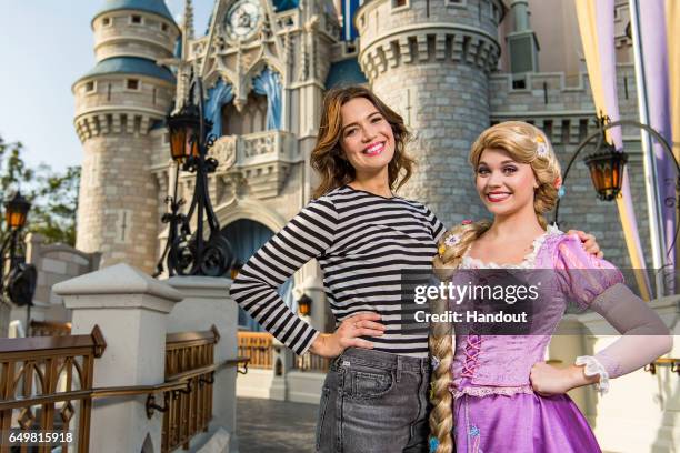 In this handout photo provided by Disney Resorts, actress Mandy Moore poses with Rapunzel during a visit to the Magic Kingdom Park on March 6, 2017...