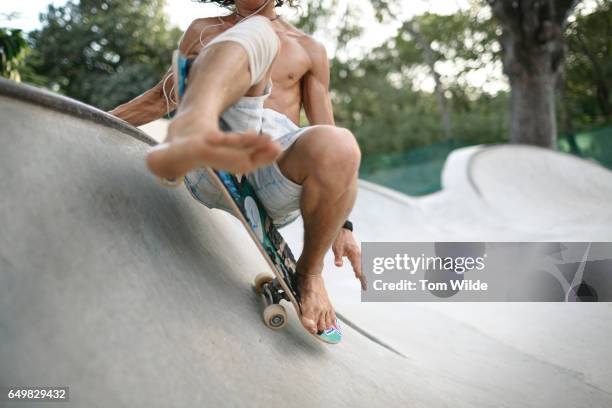 barefoot young male skateboarder skates in a a concrete bowl - bare feet male tree stock pictures, royalty-free photos & images