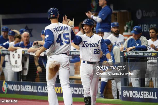 Infielder Nate Freiman of Israel high fives with his team mate Infielder Tyler Krieger after scoring a run by a RBI single of Catcher Ryan Lavarnway...