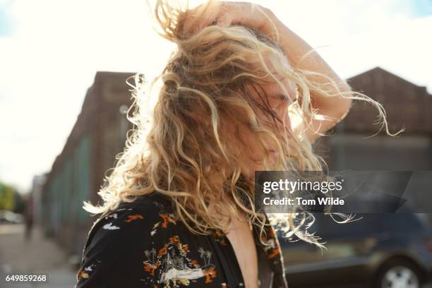 young man with curly blonde hair covering his face - long hair man stock pictures, royalty-free photos & images