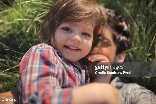 daughter with father smiling on grass - newnaivetytrend ストックフォトと画像