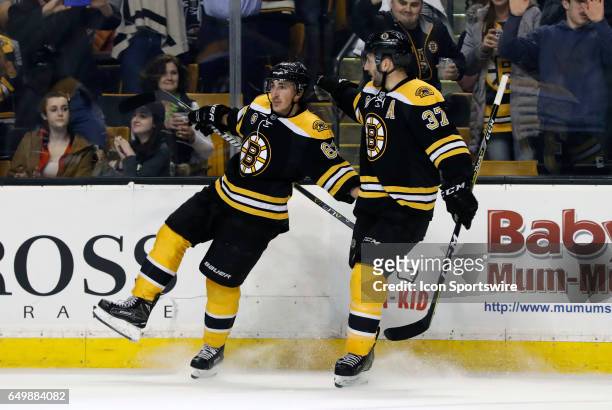 Boston Bruins left wing Brad Marchand celebrates the first of his two goals with Boston Bruins center Patrice Bergeron during a regular season NHL...