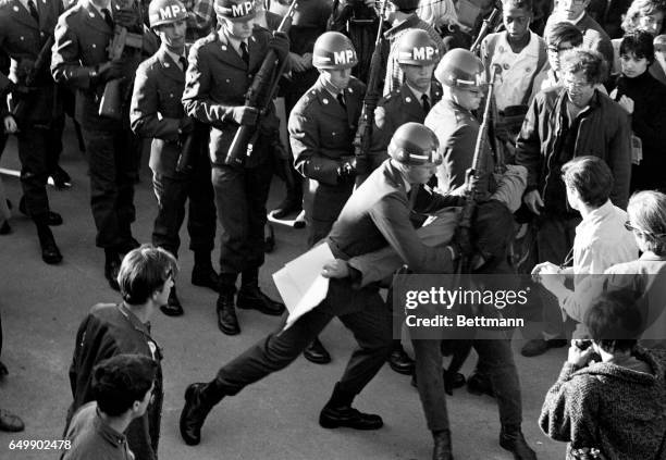 Military policeman uses his rifle to restrain a demonstrator during a mammoth anti-Vietnam War protest in front of the Pentagon 10/21.