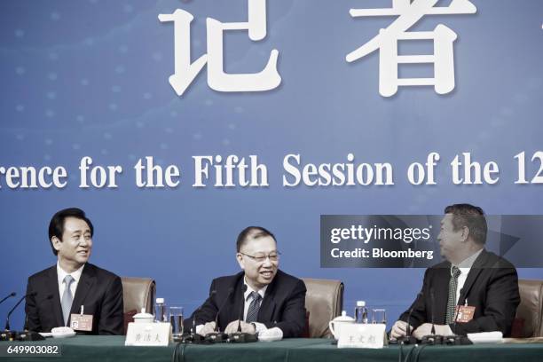 Billionaire Hui Ka Yan, chairman of China Evergrande Group, left, speaks with Wang Wenbiao, chairman of Elion Resources Group Co., right, as Jiefu...