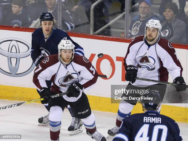 Compher, John Mitchell of the Colorado Avalanche, Shawn Matthias and Joel Armia of the Winnipeg Jets eye the flying puck during second period action...