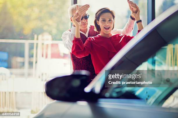 man surprising woman with a new car - new husband stock pictures, royalty-free photos & images