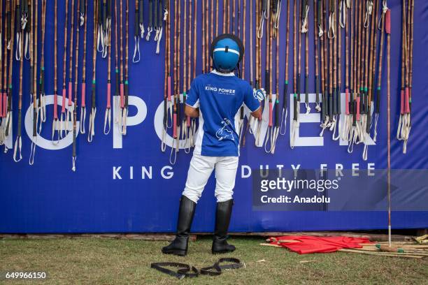 Polo player chooses his club before riding an elephant during the 2017 King's Cup Elephant Polo at Anantara Chaopraya Resort in Bangkok, Thailand on...