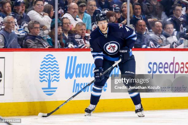 Paul Postma of the Winnipeg Jets plays the puck along the boards during second period action against the San Jose Sharks at the MTS Centre on March...