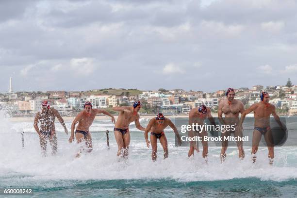 Members of the International All-Stars team struggle to stand by the pool for the National Anthem before the start of Water Polo by the Sea at Bondi...