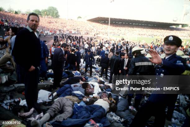 Belgian policemen mill around in the aftermath of the Heysel disaster, unsure of how to proceed