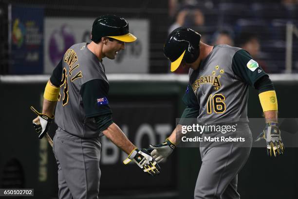 Infielder Luke Hughes of Australia celebrates with his team mate Tim Kennelly after hitting a two run homer in the top of the third inning to make it...