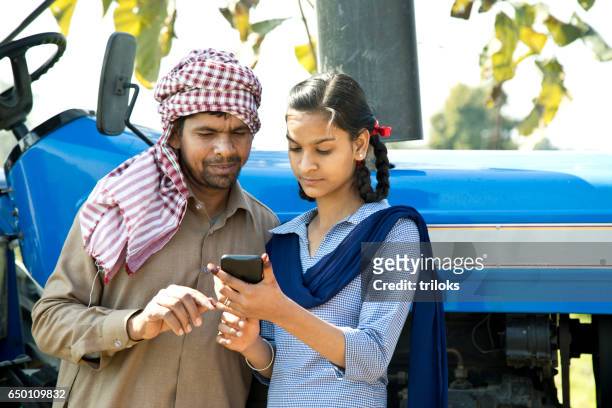 farmer with daughter using mobile phone - village stock pictures, royalty-free photos & images