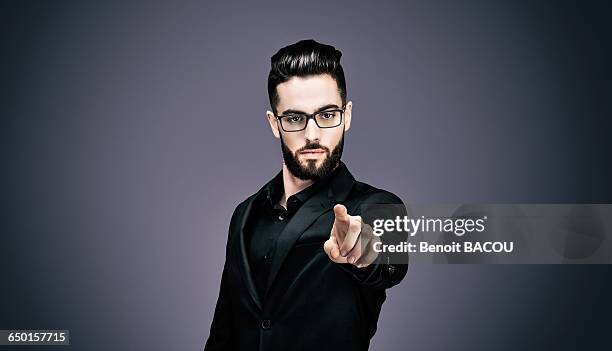 portrait of a young businessman pointing to the lens - banker portrait imagens e fotografias de stock