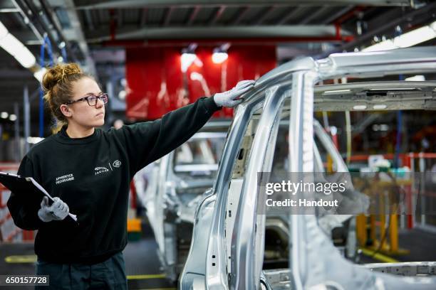 In this handout photo provided by Jaguar Land Rover, Molly Cartwright - Advanced Apprentice is photographed at the Jaguar Land Rover factory on March...