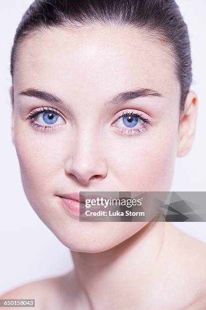 head and shoulder shot of beautiful young woman with blue eyes - natural portrait studio shot white background stock-fotos und bilder