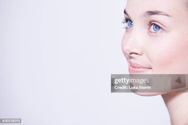 head shot of beautiful young woman with blue eyes - natural portrait studio shot white background stock-fotos und bilder