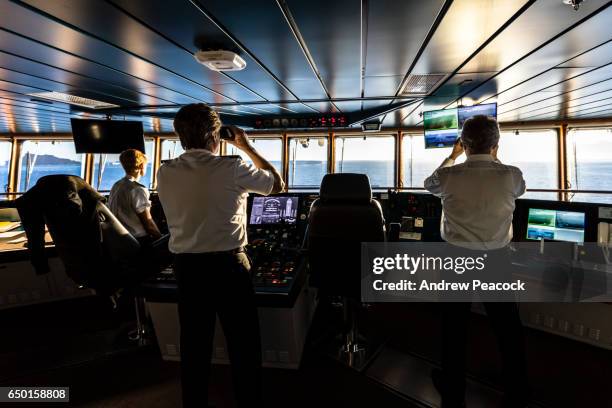 captain and officers on the bridge of a ship. - ship's bridge foto e immagini stock