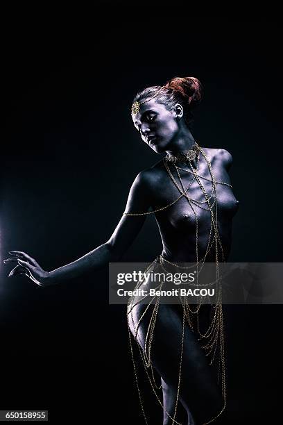 young woman in light of ethnic ceremony, length, profile, one hand on the side, looking down - visage danseuse photos et images de collection