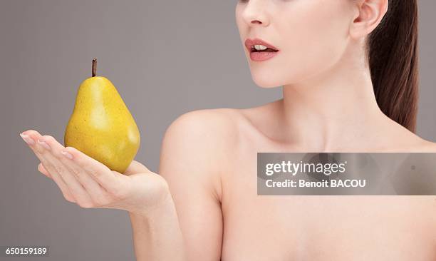 portrait of a young woman holding a pear in his hand - pear stock pictures, royalty-free photos & images