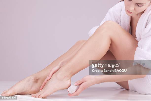 young woman using a pumice stone - pretty female feet stock-fotos und bilder