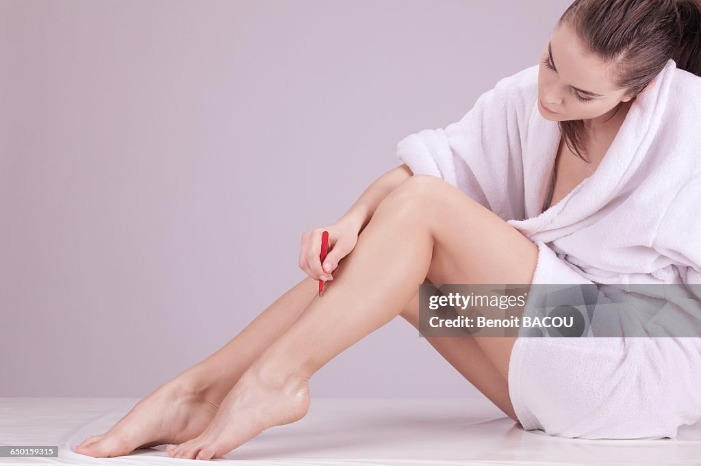 Young woman plucking with tweezers