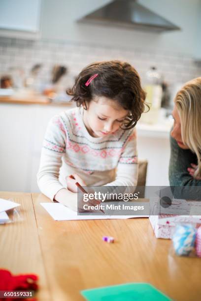 a girl at a table drawing in a card, a letter to santa. - christmas colouring stock pictures, royalty-free photos & images