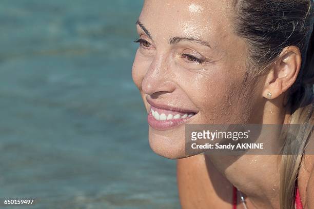 close-up of profil smiling blond woman lying in water - older woman wet hair stock pictures, royalty-free photos & images
