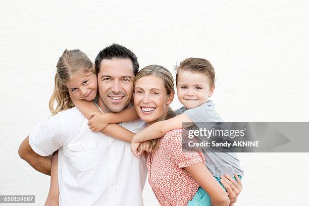 family portrait, parents with their children on their back - portrait young adult caucasian isolated stockfoto's en -beelden