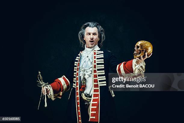 officer in uniform dragons, sings and holds a skull and a sword in his hands - opera singer portrait stock-fotos und bilder